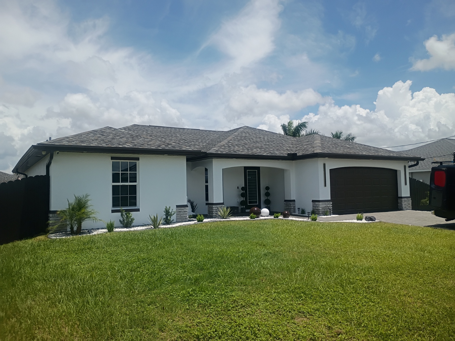 Single-story Florida home after full exterior repaint in white with dark trim
