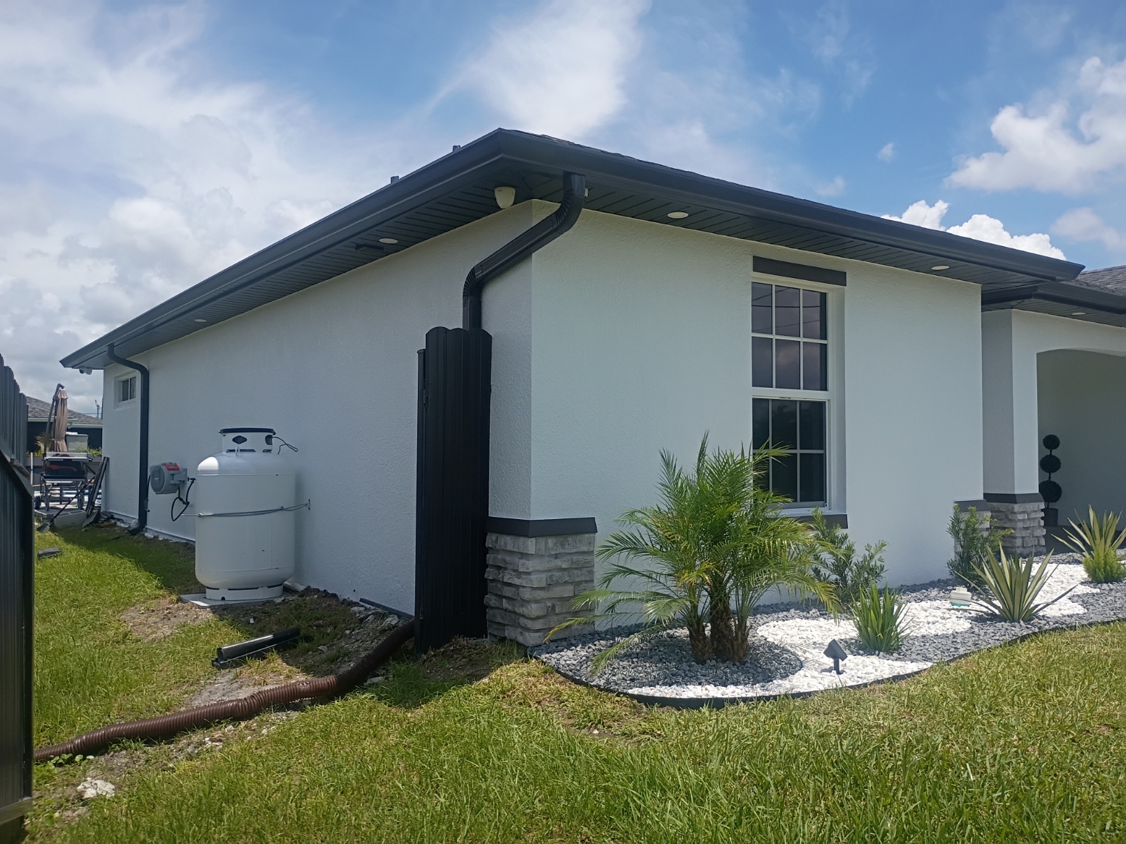 Side of home with freshly painted stucco, soffits and fascia