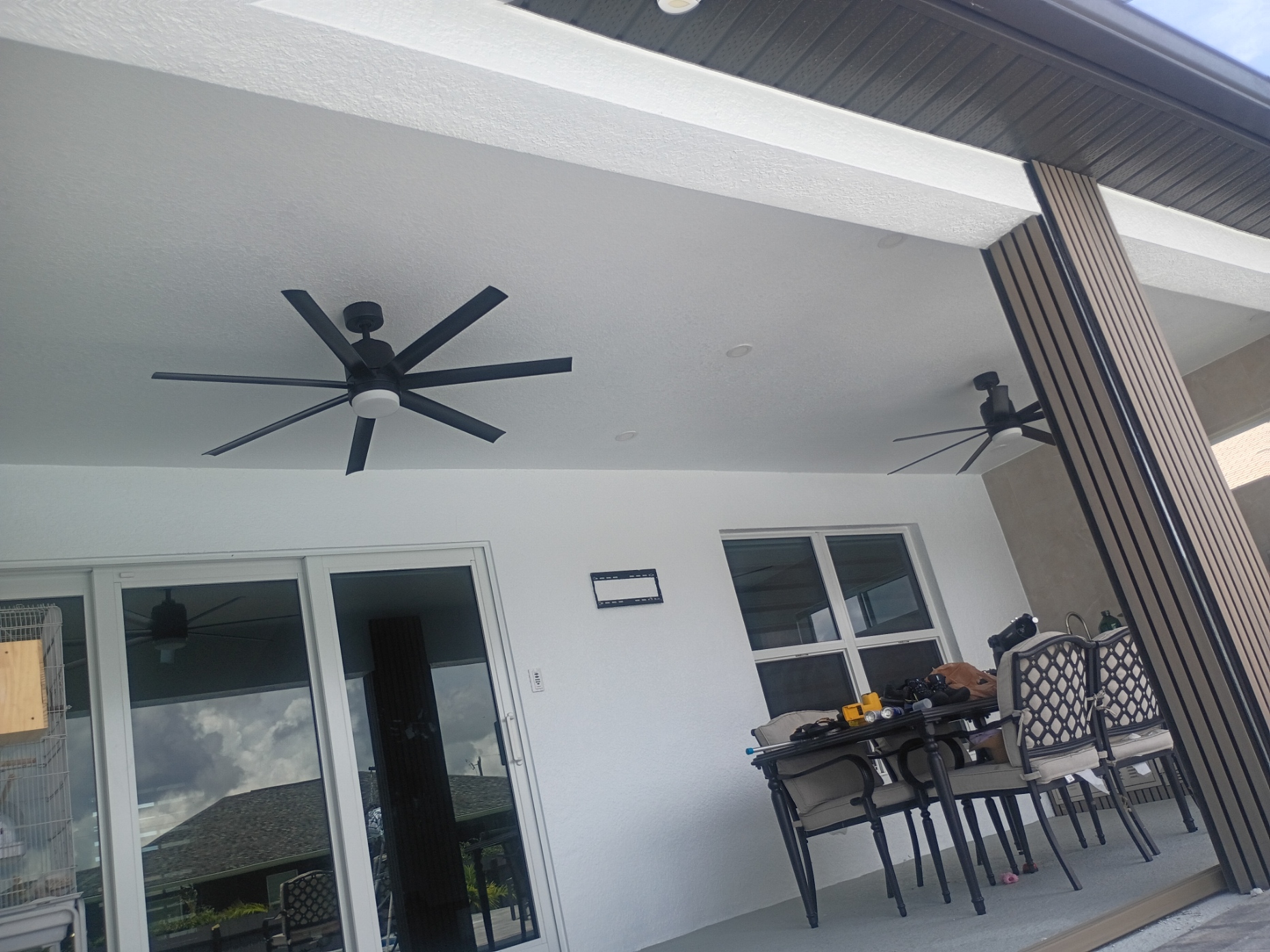 Painted lanai ceiling with black ceiling fans and crisp beam lines