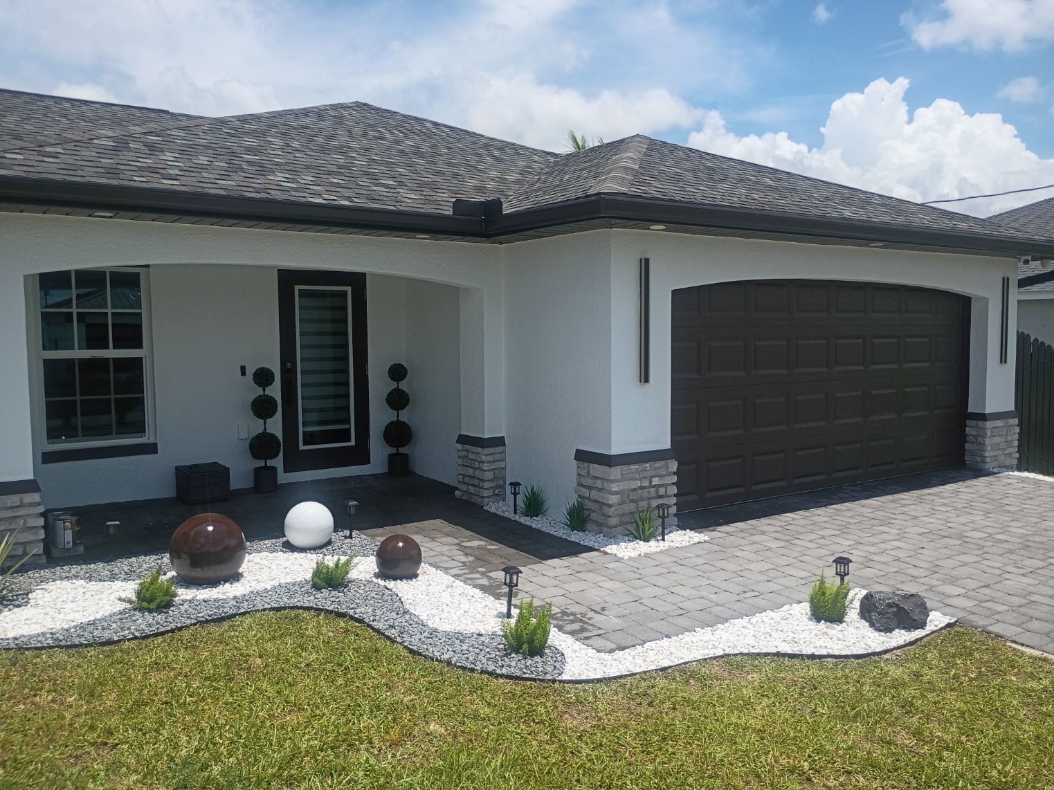 Freshly painted home entry, stone columns and garage door